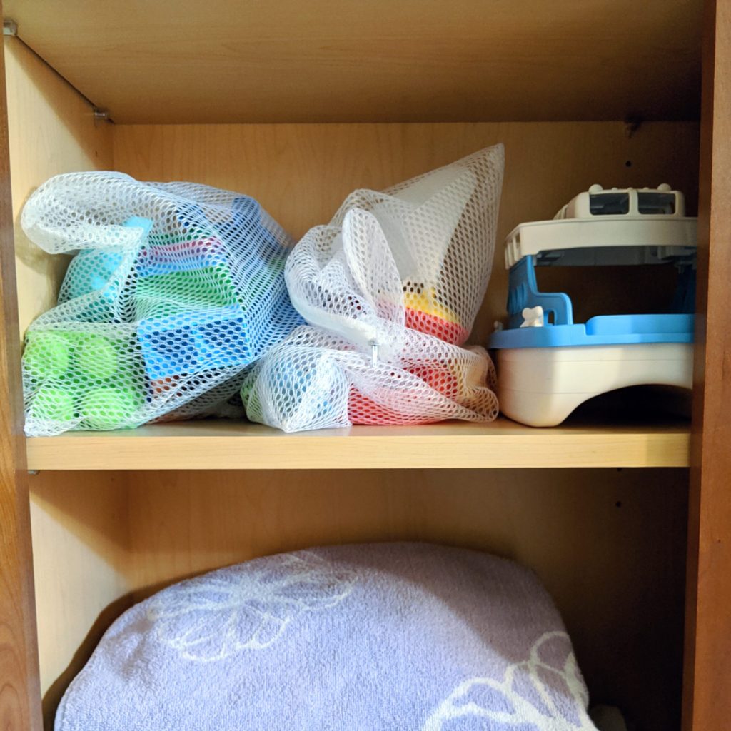 How to simplify and organize the kids' bathroom. Organize the bath toys using laundry bags from the Dollar Tree! #kidsbathroomhacks #kidsbathroom #kidsbathroomideas #organization